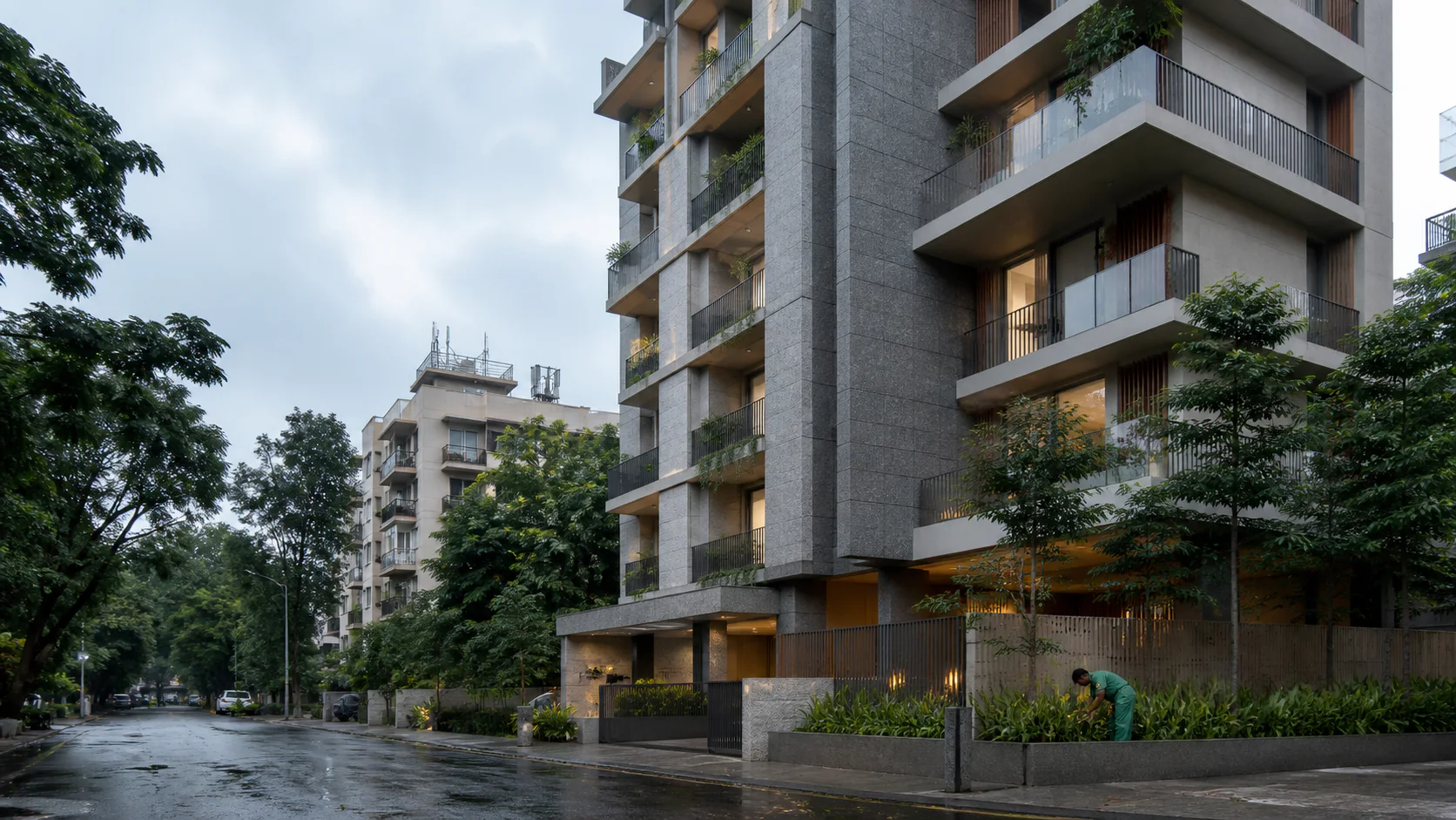A contemporary Mumbai residential building framed by mature trees and a bright overcast sky